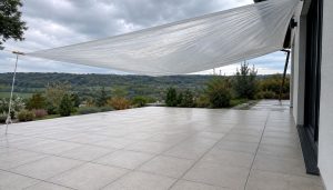 Terrasse moderne sous bâche et ciel nuageux