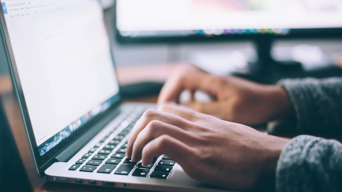 Un homme tape sur un clavier d'ordinateur